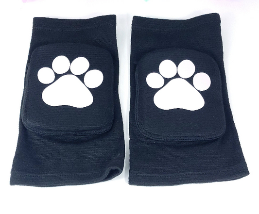 Black padded knee pads with white paw print design pair front view on white background.