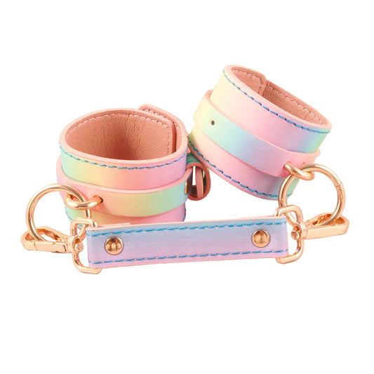 Pastel rainbow holographic PU leather wrist cuffs with rose gold hardware and spreader bar on white background.